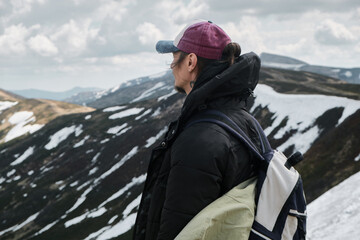Hiker in Winter Gear Overlooking Snowy Mountain Landscape
