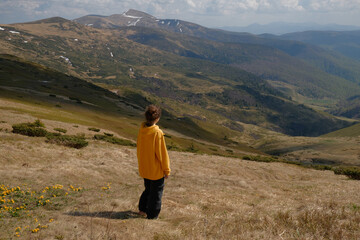 Woman in Yellow Jacket Gazing at Mountain Valley