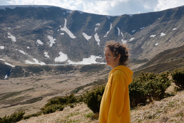 Woman in Yellow Jacket Gazing at Snow-Capped Mountains