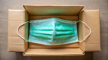Teal Face Mask In Open Brown Cardboard Box For Delivery Concept