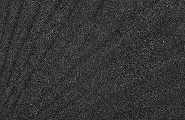Crushed quartz - black quartz sand as background, top view. Texture of black sand.