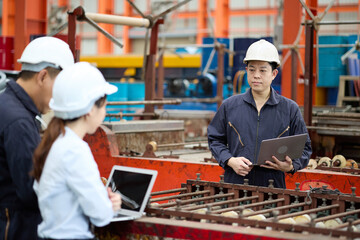Engineer or worker talking and meeting with coworker in the metal sheet factory