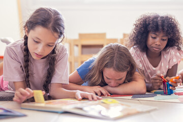Fototapeta premium students studying in classroom. Kids are concentrated in library reading a book.