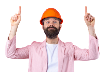 Portrait of young construction engineer wear orange hard hat, in a pink jacket standing on red studio background. The man points with his hand.