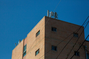 Brick Building with Rooftop Antennas under Clear Blue Sky