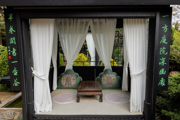Beautiful gazebo interior with table, cushions and curtains in chinese cafe