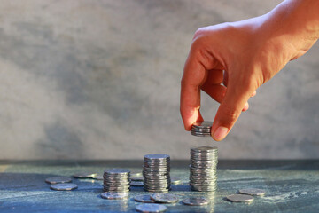Hand of businessman putting coin to money, business and finance concept.