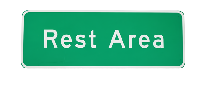 Green Rest Area Sign on Cracked Asphalt Road Surface