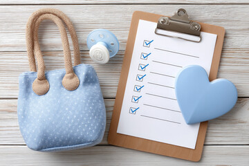 Essential maternity hospital checklist with baby accessories for new parents and delivery preparation on wooden background