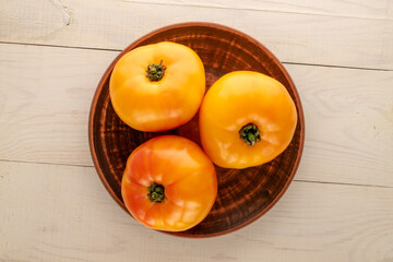 Fresh juicy tomatoes on a wooden table, close-up, top view.