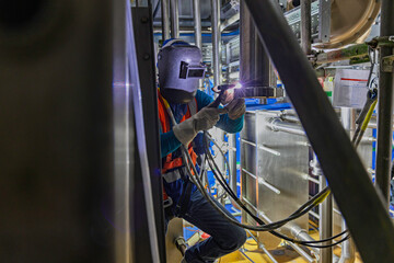 Welding arc argon worker male repaired pipeline stainless chemicals is welding sparks industrial