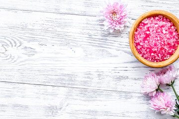 pink spa salt for aroma therapy with flower fragrance on white wooden background top view copyspace
