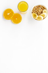 granola with banana slices and orange juice for breakfast on blue background top view copyspace