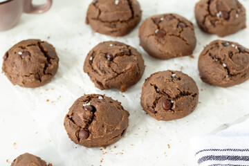 Homemade chocolate chip cookies on a parchment paper. Close-up.