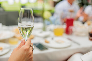champagne in hand on the background of a table in a restaurant