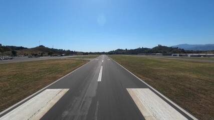Scenic pilot’s-eye view lifting off from Runway 8 at Brackett Field Airport in La Verne, California. The shot captures surrounding hills, a reservoir and neatly lined nursery fields on a clear morning
