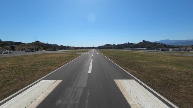 Scenic pilot&rsquo;s-eye view lifting off from Runway 8 at Brackett Field Airport in La Verne, California. The shot captures surrounding hills, a reservoir and neatly lined nursery fields on a clear morning