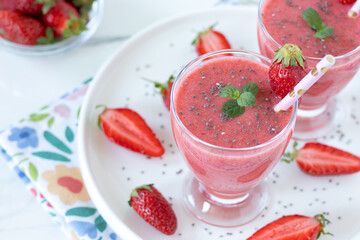 Strawberry smoothie with chia seeds in a glass. Healthy vegan drink for breakfast.