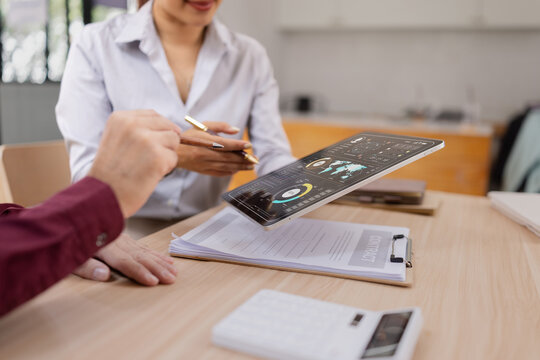 Two business holding digital tablet with futuristic interface for analytics data dashboard. - Powered by Adobe