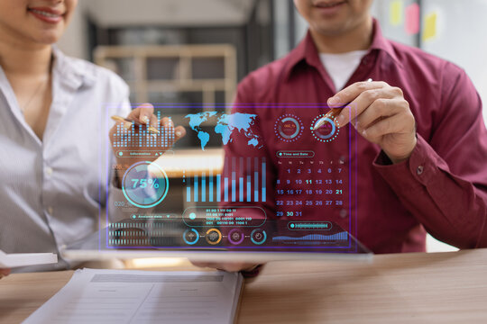 Businessman and woman holding digital tablet with futuristic interface for analytics data dashboard.
