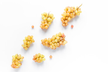 Many bunches of ripe yellow grapes on white background, top view