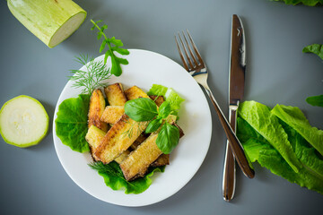 Golden fried zucchini on a gray background