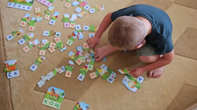 Little boy playing with word puzzles. Game, education, family, love, exercise. Down syndrome. Disabled people inclusion. Love.  