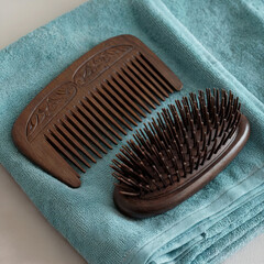 Wooden Comb and Hairbrush on Teal Towel