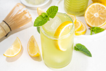 Iced Matcha Lemonade cocktail. Green iced matcha tea infused drink with lemon slices and fresh mint...