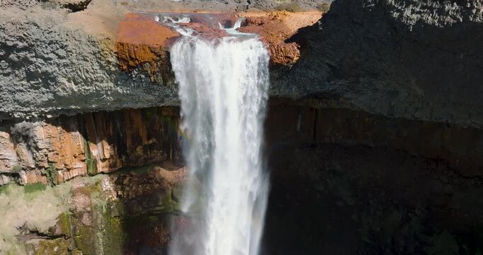 Stunning waterfall with rocky volcanic terrain and rainbow appearing. Salto del Agrio, Neuquen, Argentina