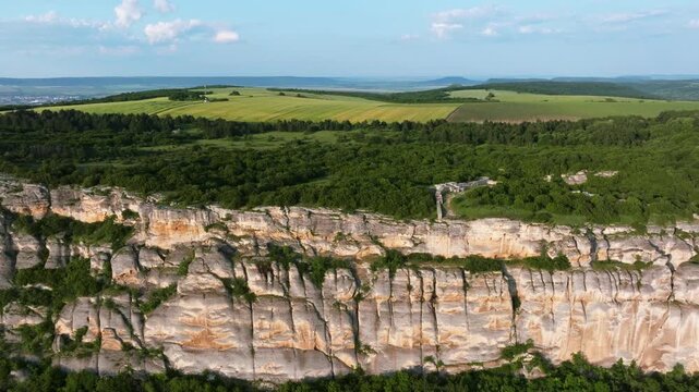 Aerial view showing majestic Madara Rider UNESCO site carved in limestone cliff near Madara village, Bulgaria, summer landscape, historical monument surrounded by forests, hills, and countryside