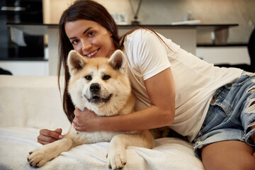 Embracing the pet. Woman is with her Shibu Inu dog at home