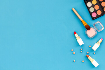 Various makeup cosmetic products - blusher, mascara, lipstick, nail polish and brushes, top view