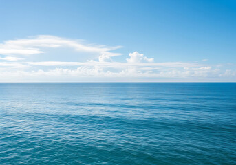 Fototapeta premium Vast blue ocean under a cloudy sky with gentle waves