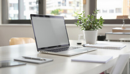 Modern home office scene with a laptop, notebook, pen, and potted plant on a white desk in natural daylight, reflecting a clean and productive workspace.