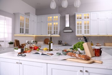 Different products and bottle of wine on counter in stylish kitchen