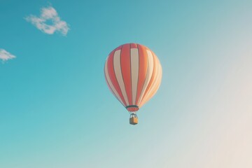 Fototapeta premium A vibrant orange and white hot air balloon gracefully floats against a serene blue sky.