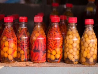 Pickled red and yellow peppers in bottles