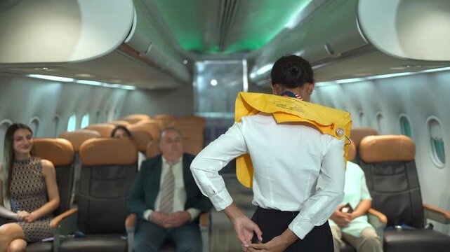 Flight attendant demonstrating the use of emergency and safety equipment to passengers onboard before takeoff.