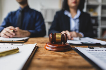 Lawyers discussing contract with gavel on table, legal proceedings and negotiations.