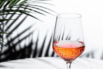 Enjoying a refreshing glass of rose pink wine at a classy restaurant setting during a lively celebration