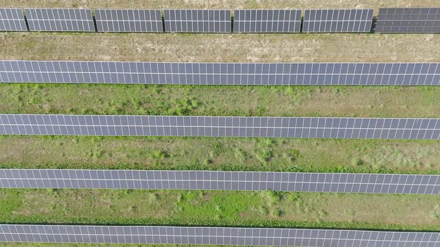 Aerial Video of Solar Farm with Parallel Solar Panels on Grass Field