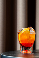Bicicletta cocktail on a dark table features layers of dry white wine, Italian red bitter, and an orange garnish.