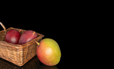 Ripe juicy mangoes on a black background, close-up.