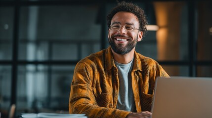 A warm genuine smile from a young professional working late radiating confidence and joy in a modern office with soft