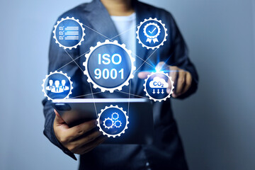 ISO 9001 quality management system concept with businessman pointing on emission reduce icon to new...