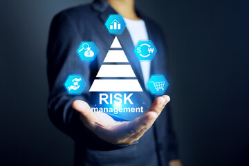 Business risk management concept with businessman holding on risk assessment icon to reduce factor...