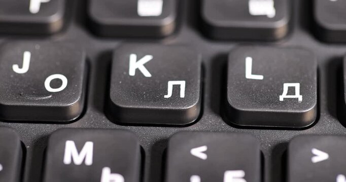 black keyboard with Russian and English letters in white, bilingual computer keyboard layout with Latin and Cyrillic alphabet