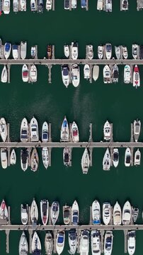 Aerial view of a marina with yachts and boats neatly moored in parallel rows seen from directly above.	
