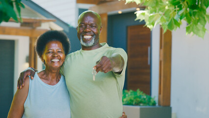 Portrait Of Senior Couple Outdoors Holding Keys To Dream Home